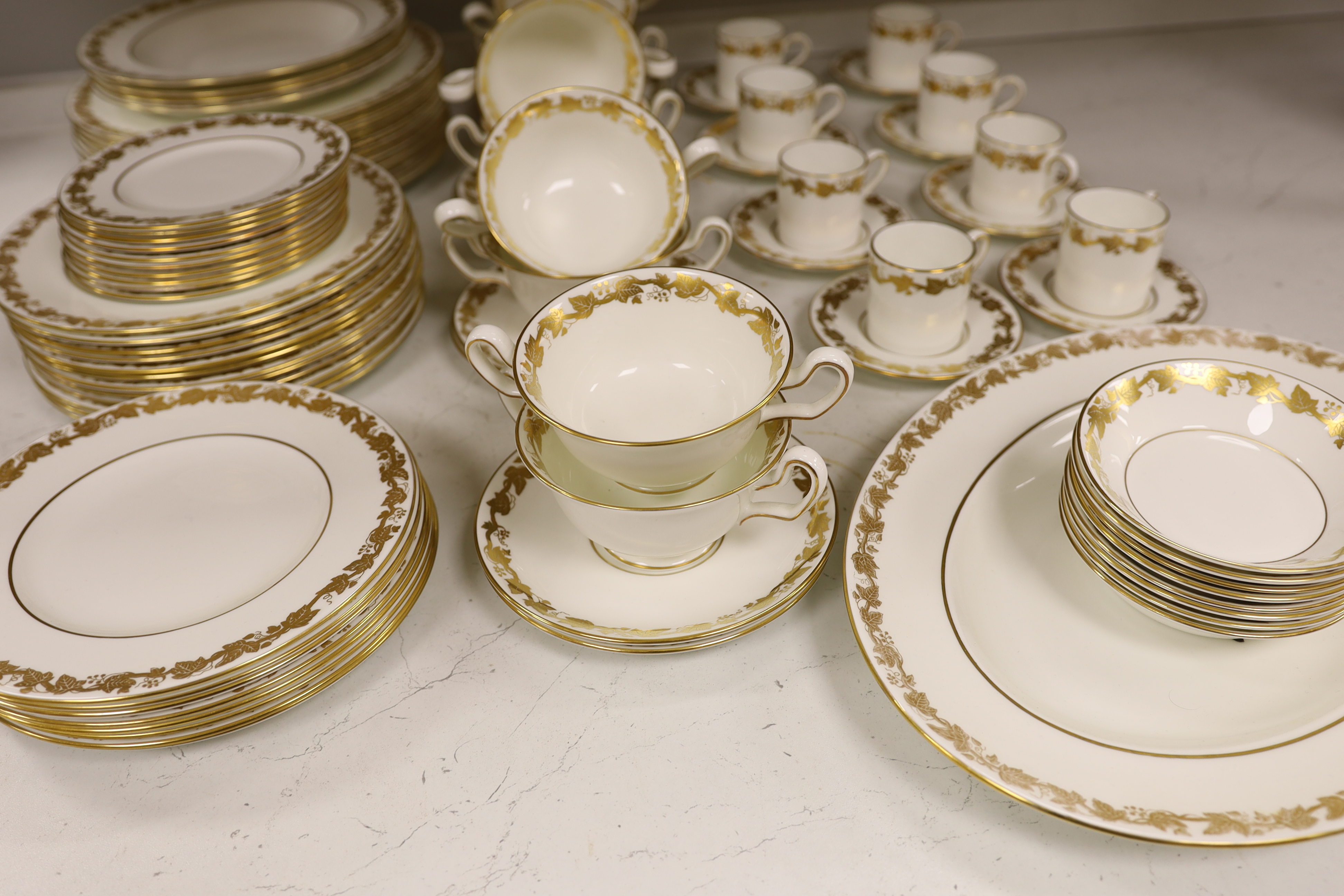 A Wedgwood gilt vine pattern dinner and coffee service for twelve